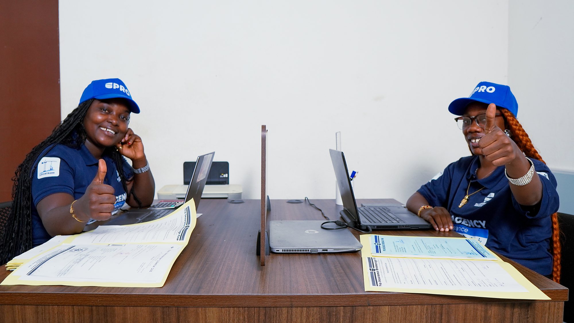 Two Pro-Insurance advisers reviewing client policy paperwork at the office
